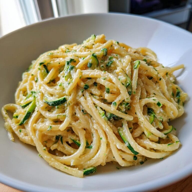 A bowl of Spaghetti mit Zucchini-Sahne-Sauce, a creamy German zucchini pasta dish.