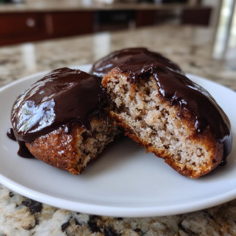 Close-up of a halved Amerikaner, a German pastry, topped with rich chocolate glaze.