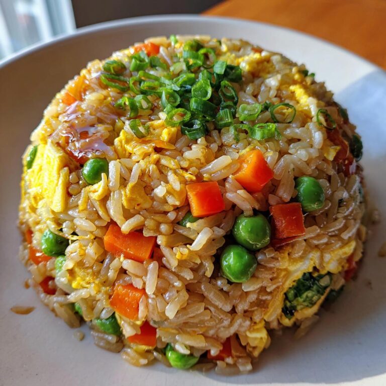 Close-up of Blitz-Bratreis Asiatisch featuring rice, carrots, peas, eggs, and green onions.
