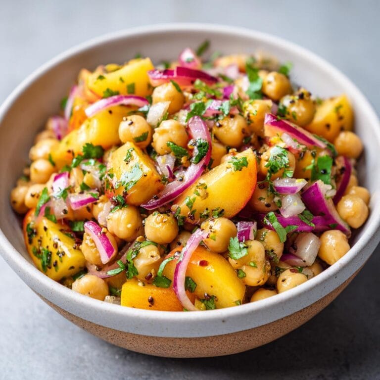 Close-up of Chickpea Peach Salad with Honey Lime Dressing, featuring chickpeas, peaches, red onion, and herbs.