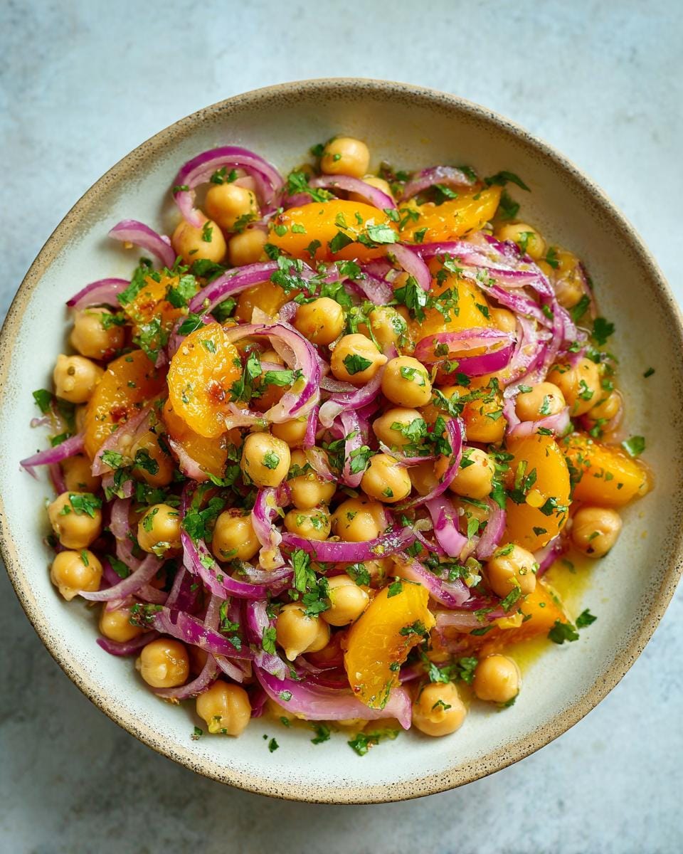 Overhead view of Chickpea Peach Salad with Honey Lime Dressing, featuring chickpeas, peaches, red onion, and herbs.