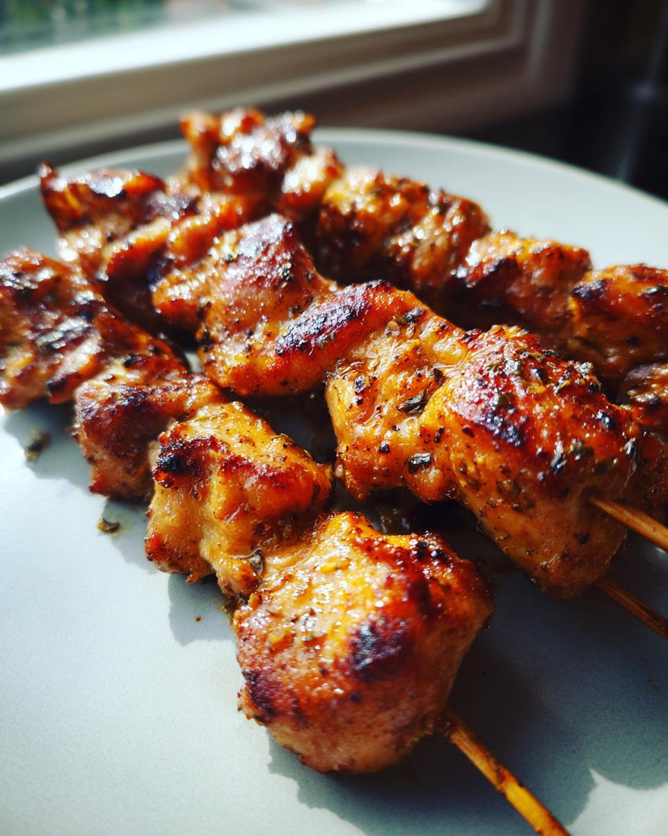 Close-up of delicious Hähnchenspieße aus der Heißluftfritteuse on a plate, cooked to perfection.