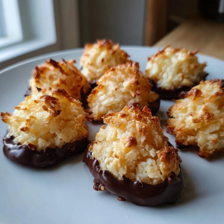 Delicious homemade Haselnussmakronen Rezept dipped in chocolate on a plate.