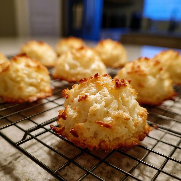 Close-up of golden brown Kokosmakronen cooling on a wire rack. Delicious German coconut macaroons.