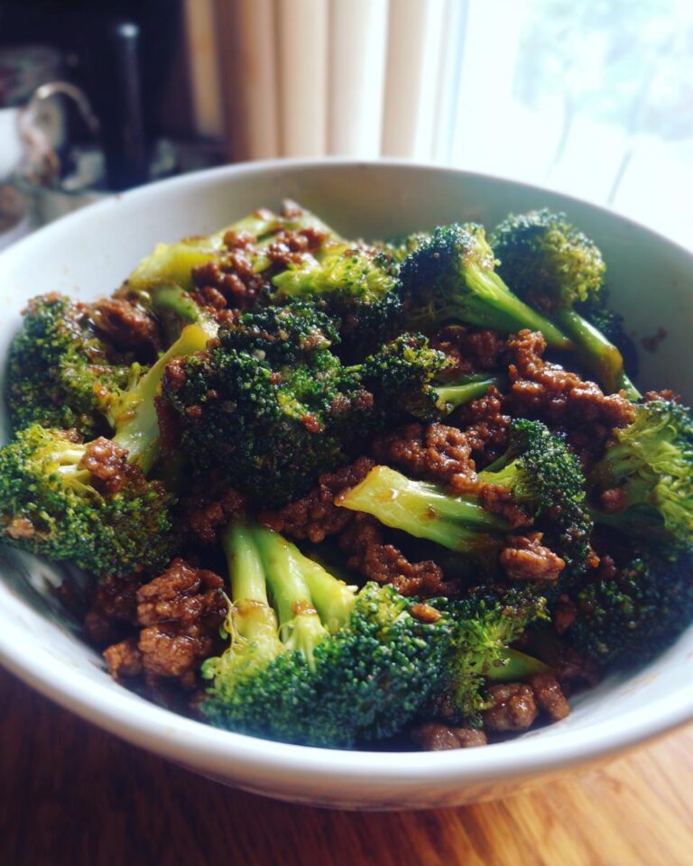 Close-up of Rindfleisch mit Brokkoli (beef with broccoli) in a white bowl, ready to eat.
