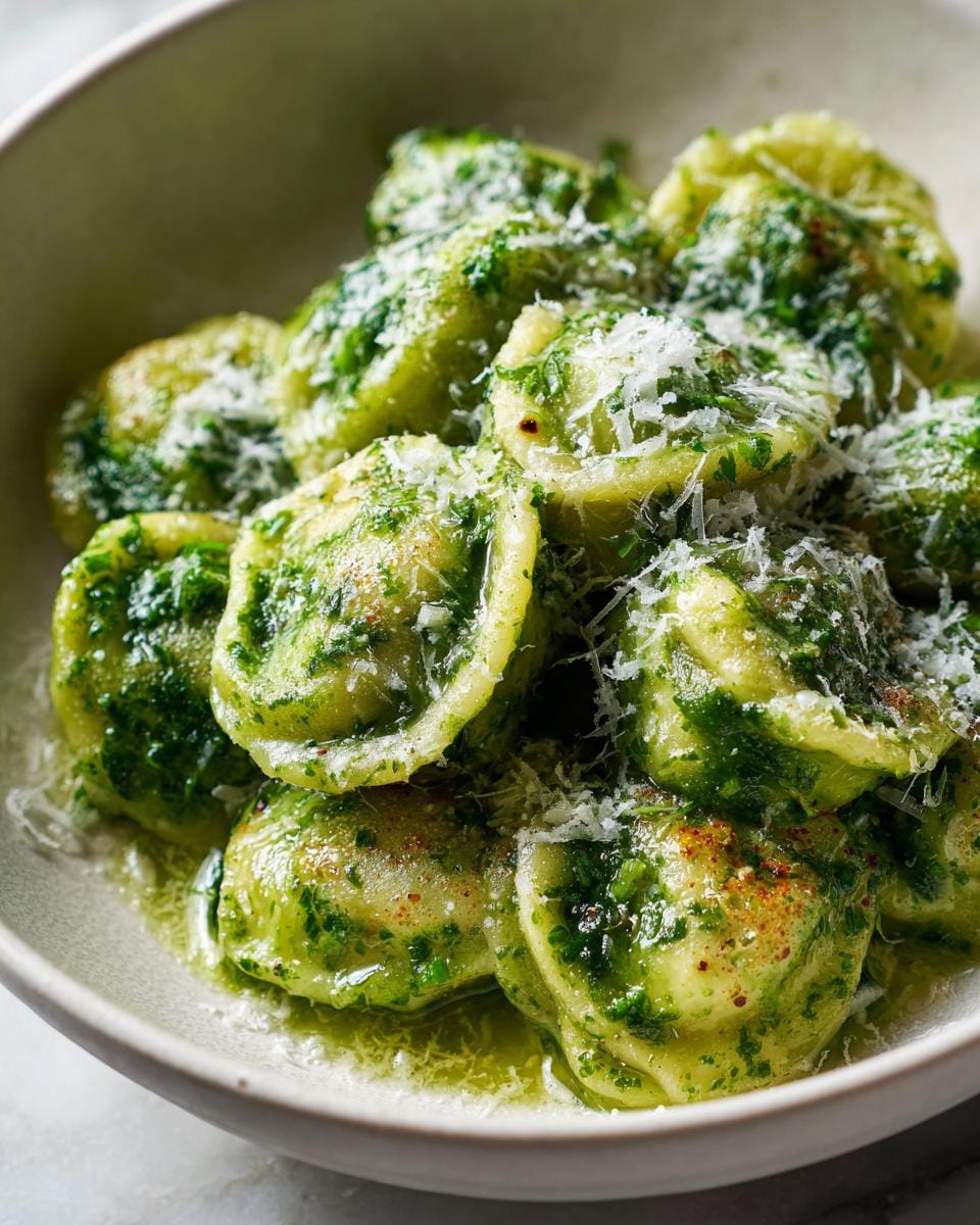 Close-up of Spinatknödel, a vegetarian recipe for lunch, topped with pesto and parmesan cheese.