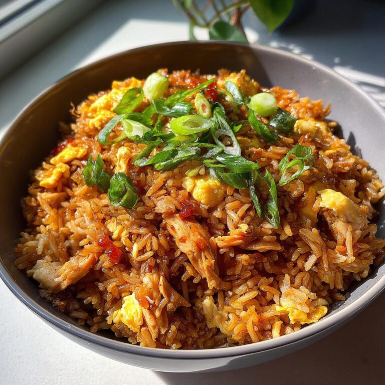 Schüssel mit Gebratenem Reis mit Huhn und Ei, garniert mit Frühlingszwiebeln.