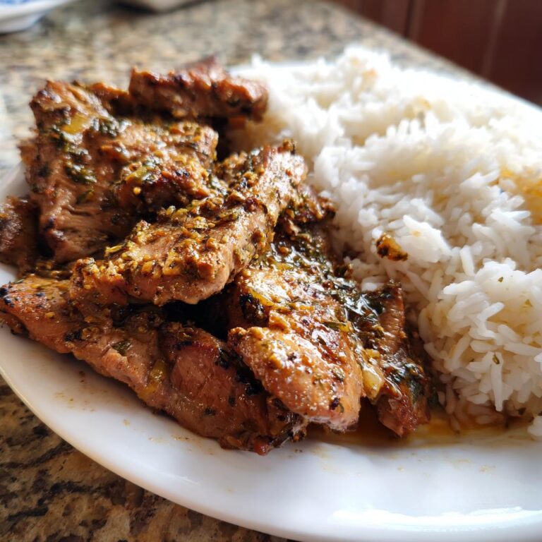 Eine Nahaufnahme von Gyros Geschnetzeltes mit Reis, das Fleisch ist mariniert und mit Kräutern bestreut.