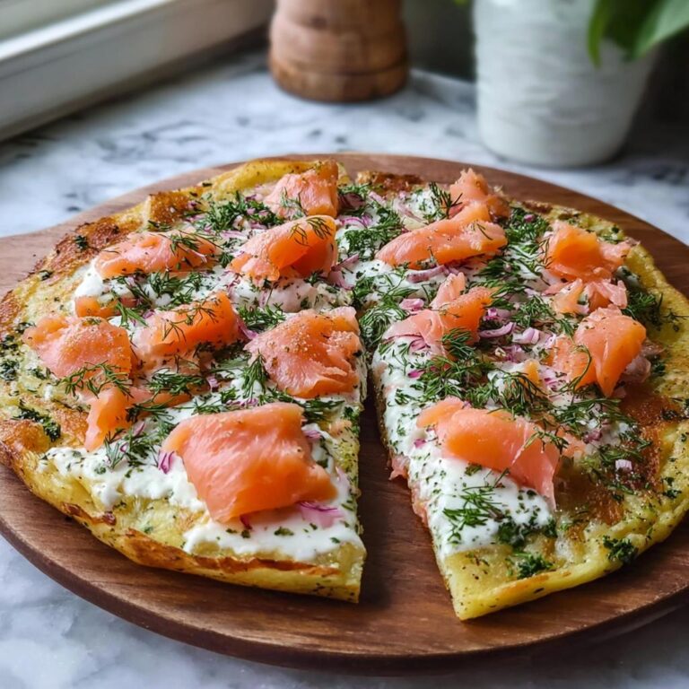 Fertige Einfache Kartoffelpizza mit geräuchertem Lachs, frischem Dill und roter Zwiebel auf einem Holzbrett.