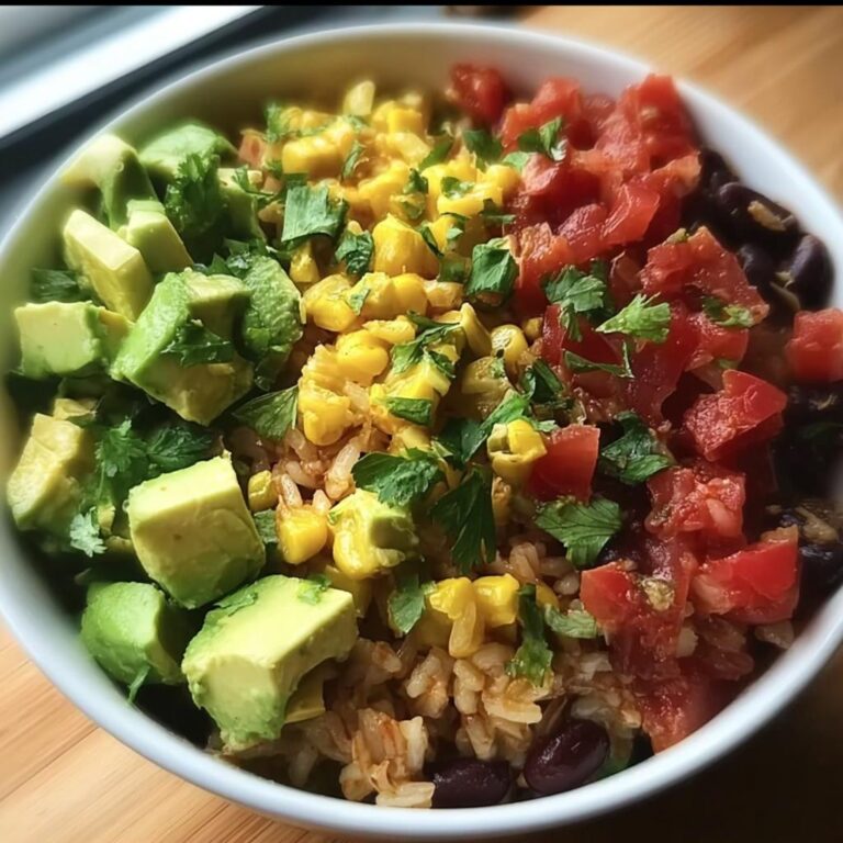 Nahaufnahme einer farbenfrohen Burrito-Bowl mit Reis, schwarzen Bohnen, Mais, gewürfelten Tomaten und Avocado.