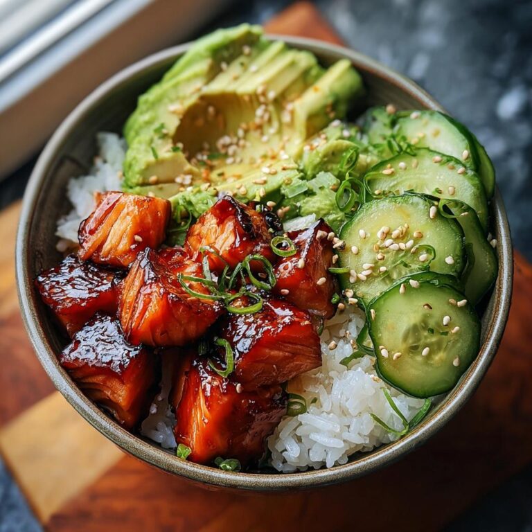 Nahaufnahme einer Lachs-Teriyaki-Bowl mit Reis, glasierten Lachs-Würfeln, Avocado und Gurkenscheiben.
